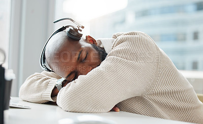 Buy stock photo Shot of a handsome young businessman sleeping on his desk during the day