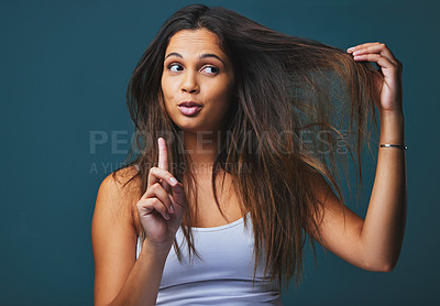 Buy stock photo Haircare, studio and woman with hand, unhappy and cosmetics for hair, aesthetic and doubt with treatment. Results, pointing and hairstyle for girl, texture and blue background in Brazil and salon