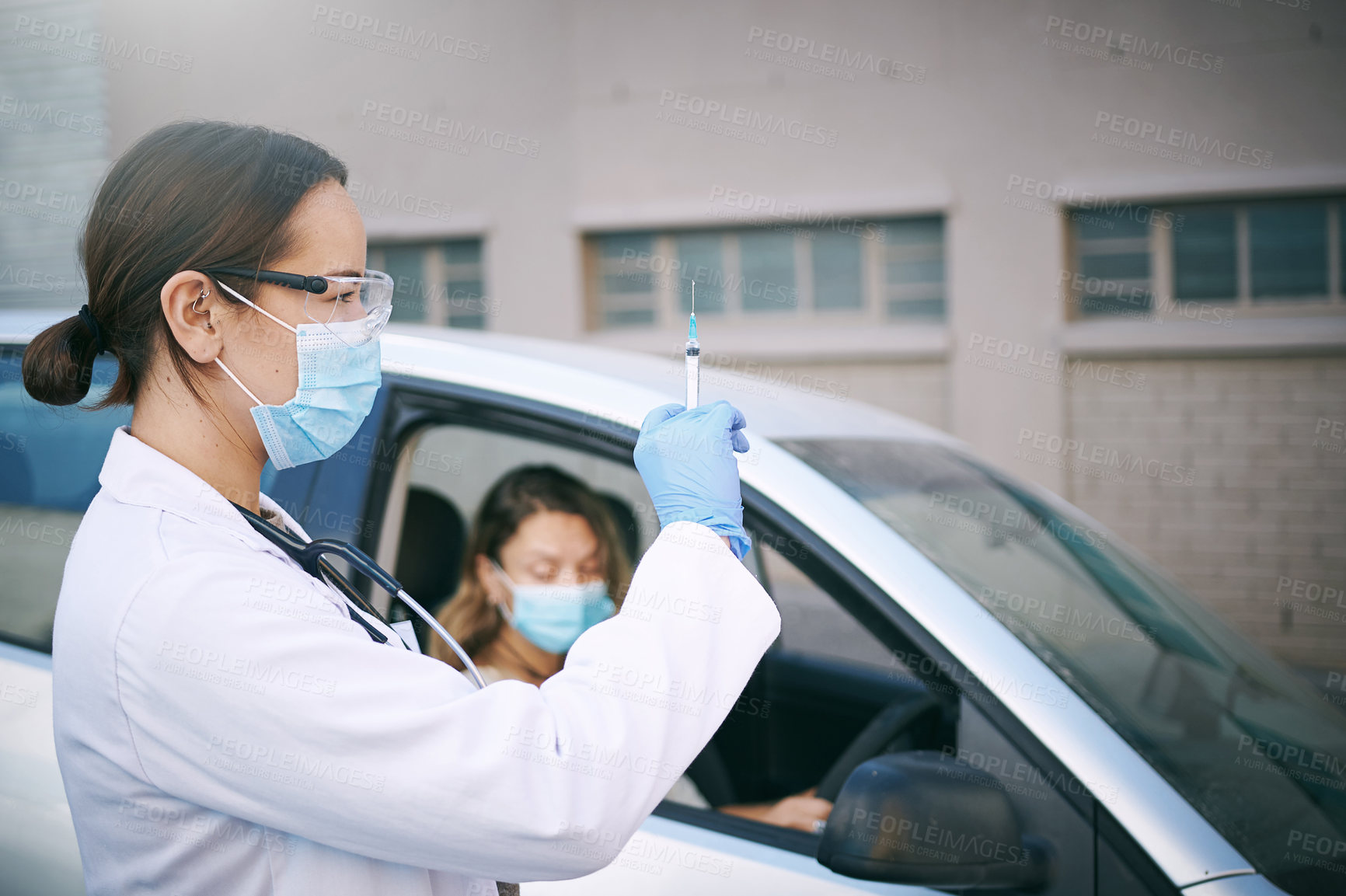 Buy stock photo Shot of a masked young doctor giving a patient an injection at a Covid-19 drive through testing centre