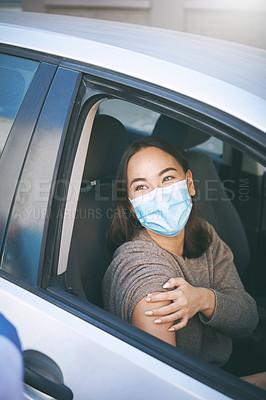 Buy stock photo Shot of a masked young woman getting a Covid-19 test in her car at a drive through centre