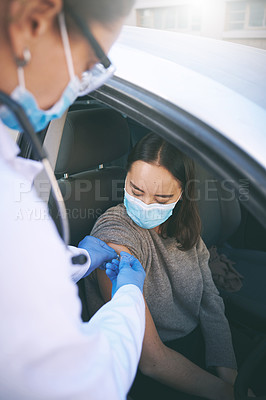 Buy stock photo Shot of a masked young doctor giving a patient an injection at a Covid-19 drive through testing centre