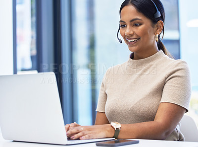 Buy stock photo Shot of a young businesswoman wearing a headset while working on a laptop an office