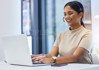 Buy stock photo Shot of a young businesswoman wearing a headset while working on a laptop an office