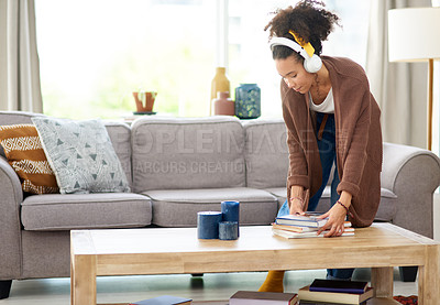 Buy stock photo Shot of a woman wearing headphones while busy cleaning at home
