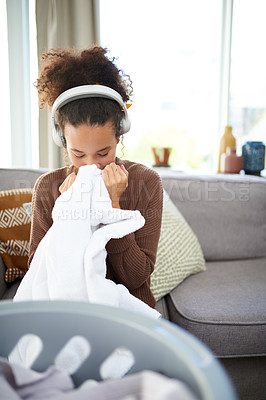 Buy stock photo Shot of a woman smelling freshly washed laundry while sitting at home
