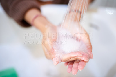 Buy stock photo Cropped shot of an unrecognizable woman washing her hands at home