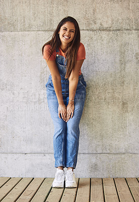 Buy stock photo Fashion, smile and portrait of woman by wall with casual, trendy and dungaree outfit with sneakers. Happy, stylish and full body of female person with denim, trendy and funky clothes for confidence.