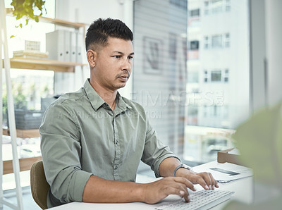 Buy stock photo Shot of a businessman using his computer while sitting at his desk