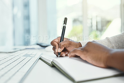 Buy stock photo Cropped shot of an unrecognizable businesswoman writing in her notebook while sitting at her desk