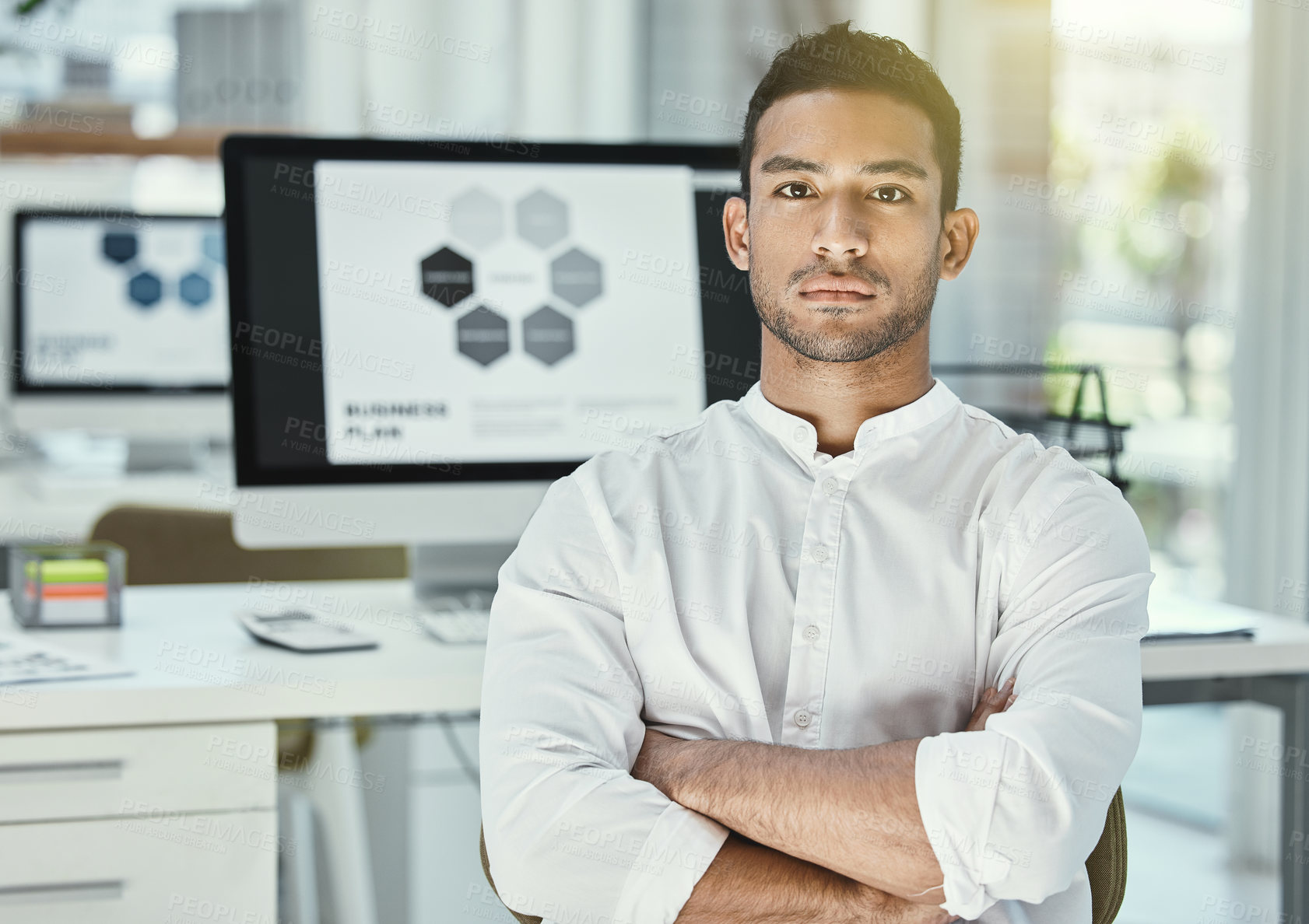 Buy stock photo Businessman, portrait and arms crossed in office with computer screen for research, analysis and project. Male developer, software and technology in workplace for review, media and website at desk