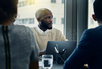 Buy stock photo Shot of a businessman using his laptop during a meeting