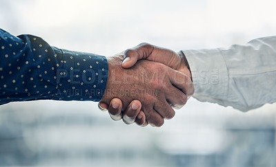 Buy stock photo Shot of two colleagues shaking hands in the office