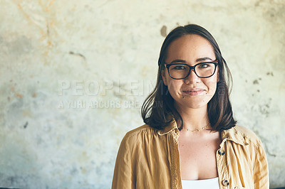 Buy stock photo Portrait of a confident young woman standing against a wall