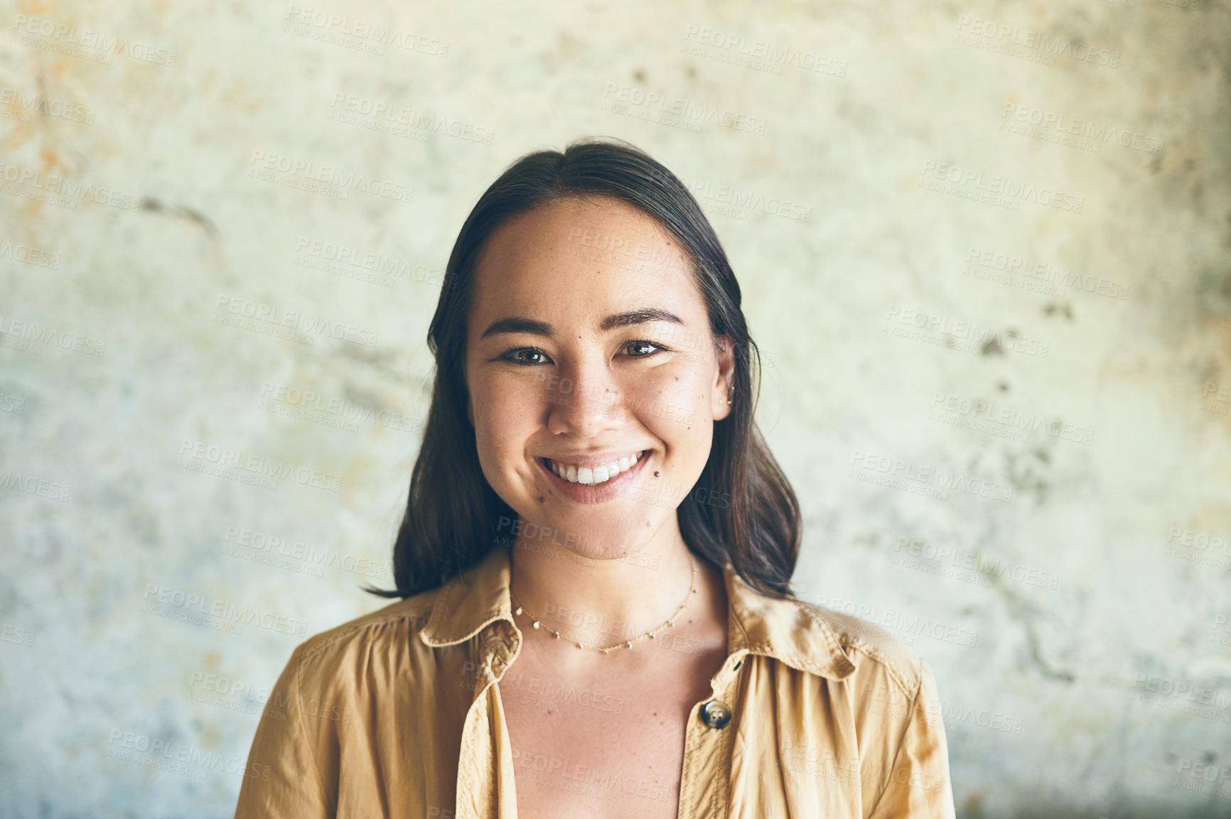 Buy stock photo Portrait of a confident young woman standing against a wall