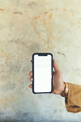 Buy stock photo Closeup shot of an unrecognisable woman holding a cellphone with a blank screen against a wall