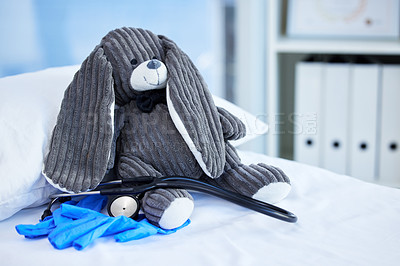 Buy stock photo Shot of a grey teddy bear on a hospital bed