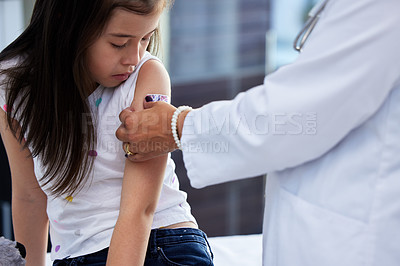 Buy stock photo Shot of a little girl getting a vaccination by a doctor in a hospital