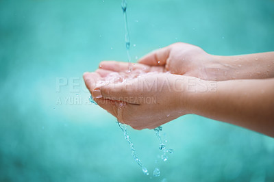 Buy stock photo Person, hands and water with drops for natural hydration, hygiene or sustainability on a blue background. Closeup of wet consumer with splash, liquid element or fresh mineral for care, hope or nature