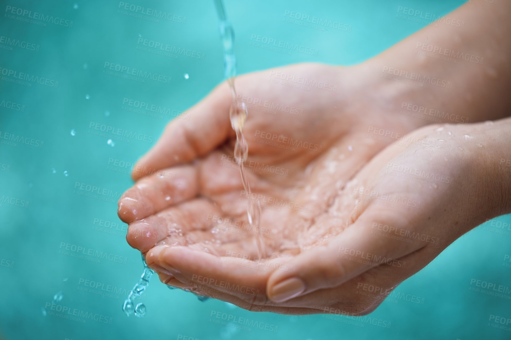 Buy stock photo Person, hands and water splash with drops for natural hydration, hygiene or sustainability on a blue background. Closeup of wet consumer with liquid element or fresh mineral for care, hope or nature