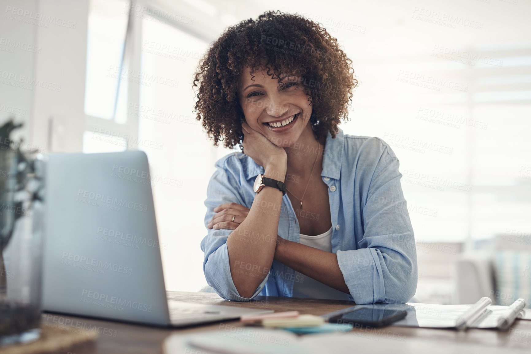 Buy stock photo Shot of an attractive young woman sitting alone at home and using her laptop