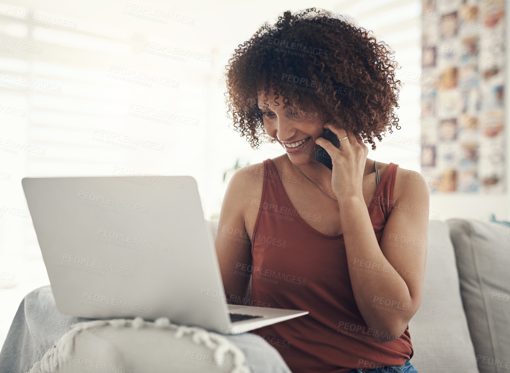 Buy stock photo Shot of an attractive young woman sitting on her sofa at home and using technology