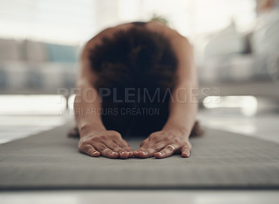 Buy stock photo Shot of an unrecognizable woman practising yoga in her living room and holding a child's pose