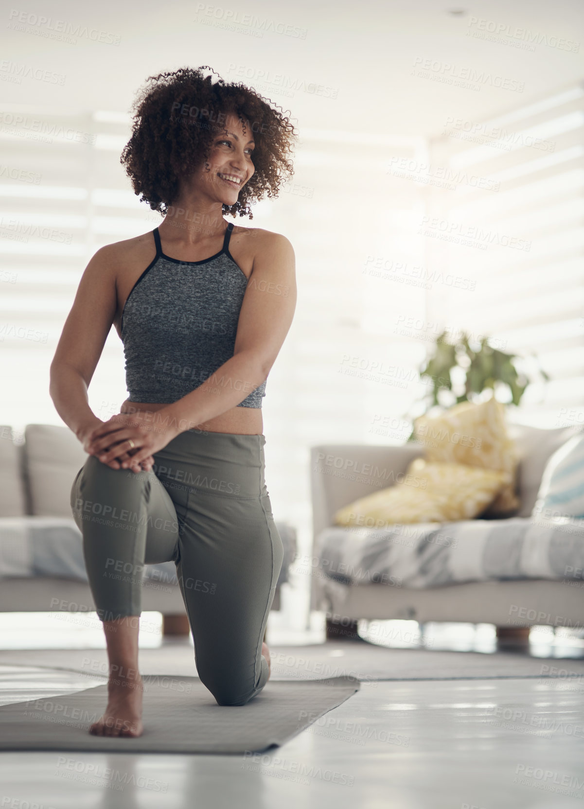 Buy stock photo Shot of an attractive young woman working out in her living room during the day