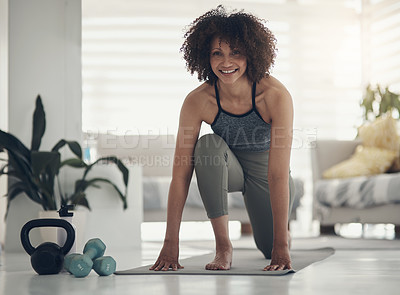Buy stock photo Shot of an attractive young woman practising yoga in her living room and holding a high lunge pose