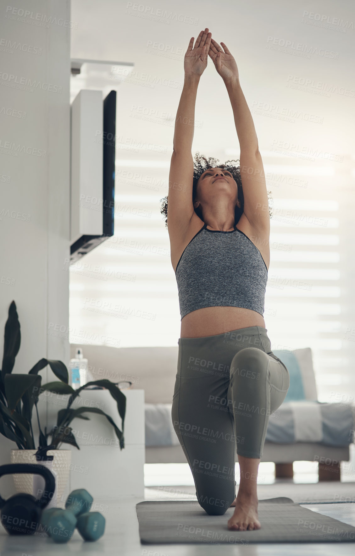 Buy stock photo Shot of an attractive young woman practising yoga in her living room