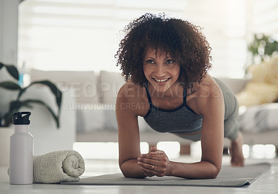 Buy stock photo Shot of an attractive young woman working out in her living room during the day