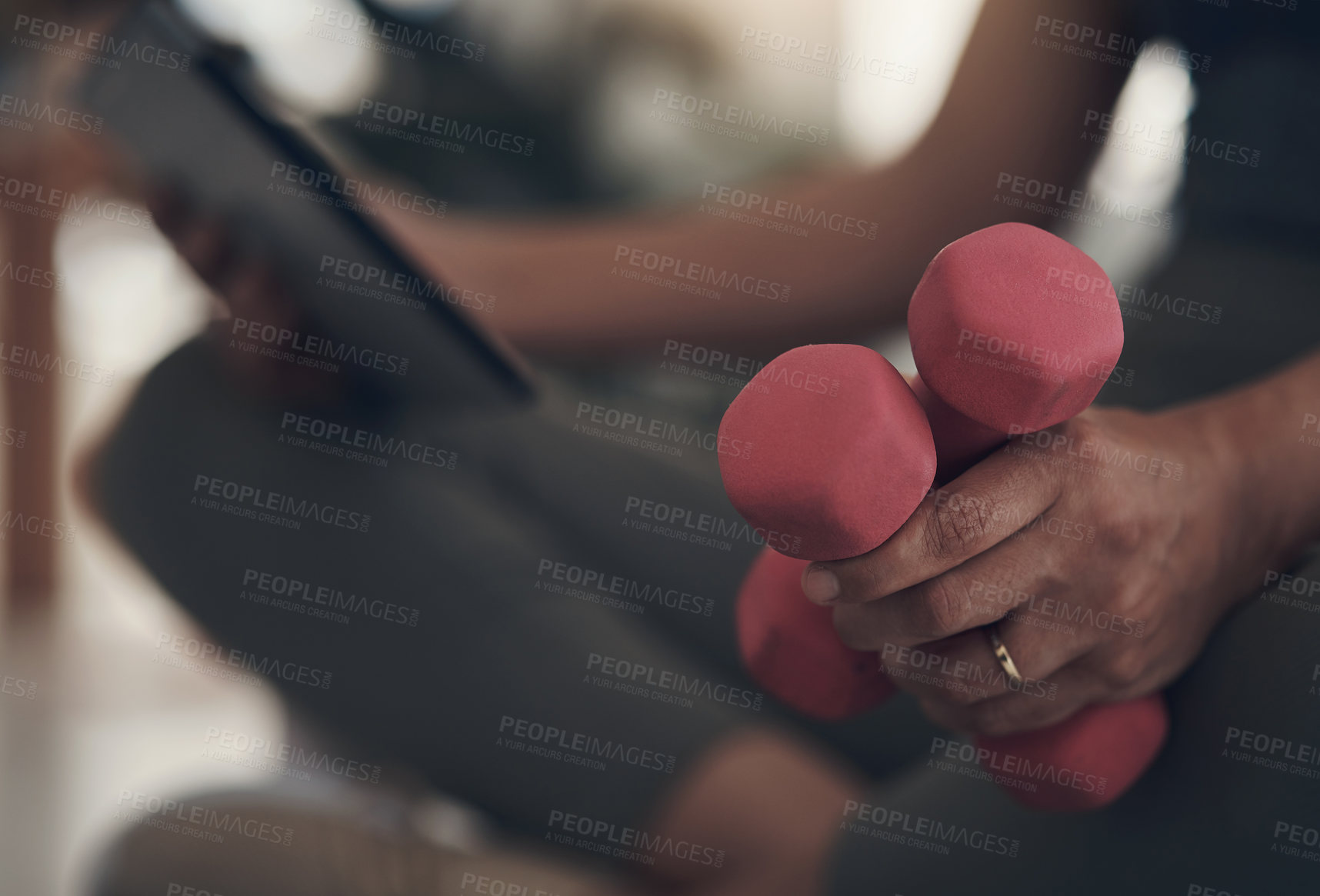 Buy stock photo Cropped shot of an unrecognizable woman sitting alone at home and holding dumbbells during a workout