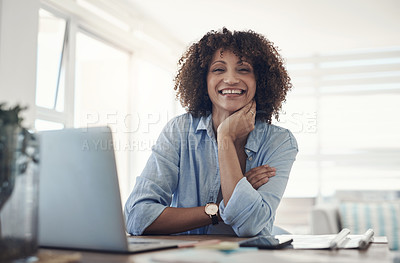 Buy stock photo Shot of an attractive young woman sitting alone at home and using her laptop