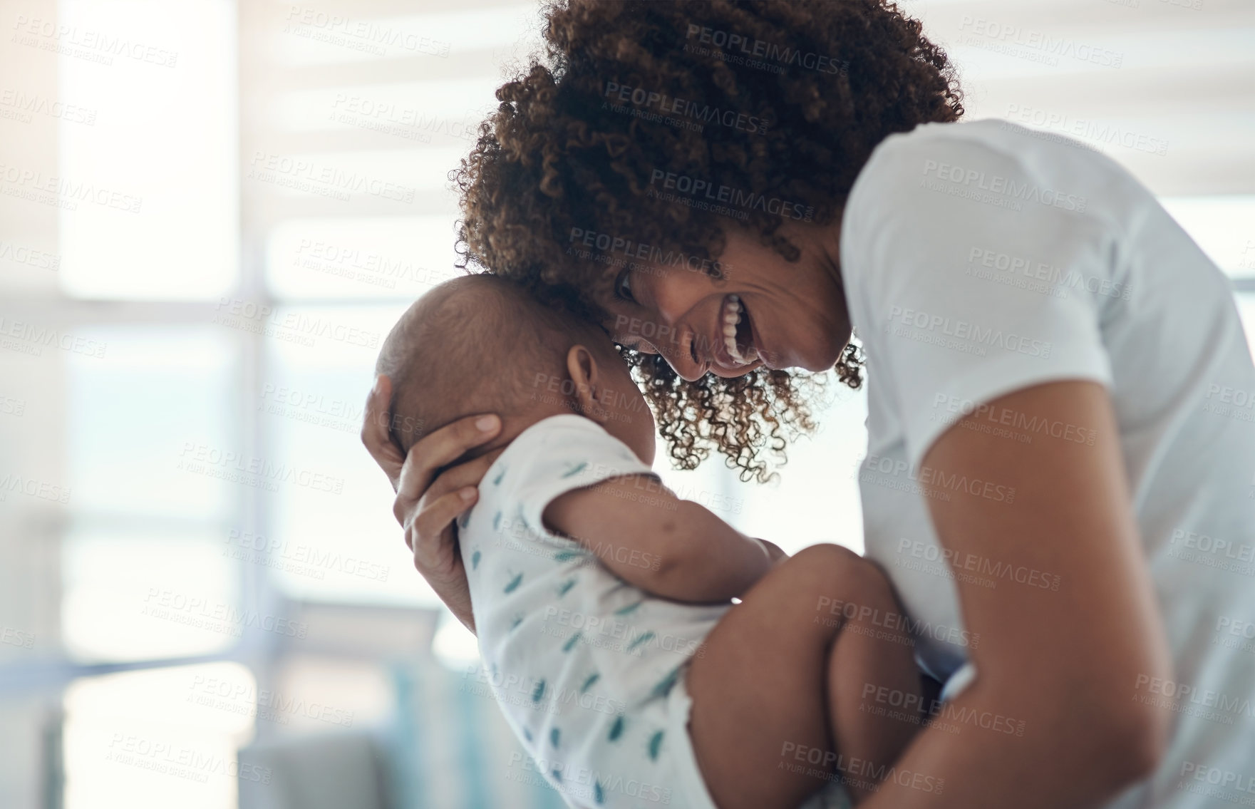 Buy stock photo Shot of a young woman carrying her adorable baby girl at home