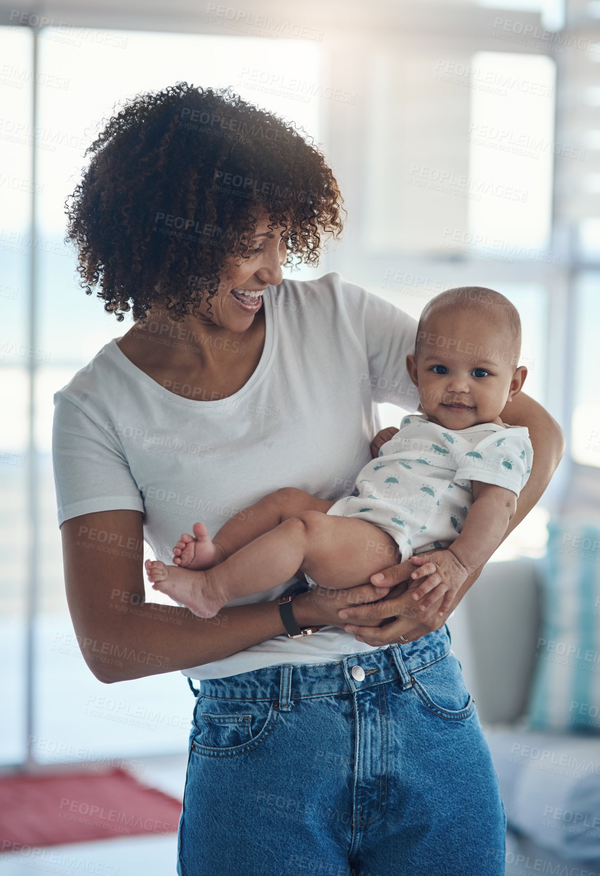 Buy stock photo Shot of a young woman carrying her adorable baby girl at home