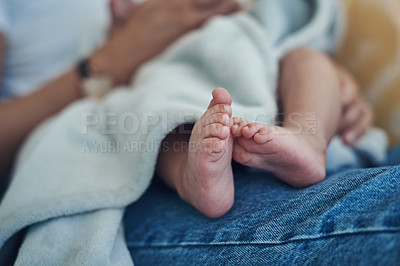 Buy stock photo Shot of an unrecognizable woman relaxing with her baby on the sofa at home