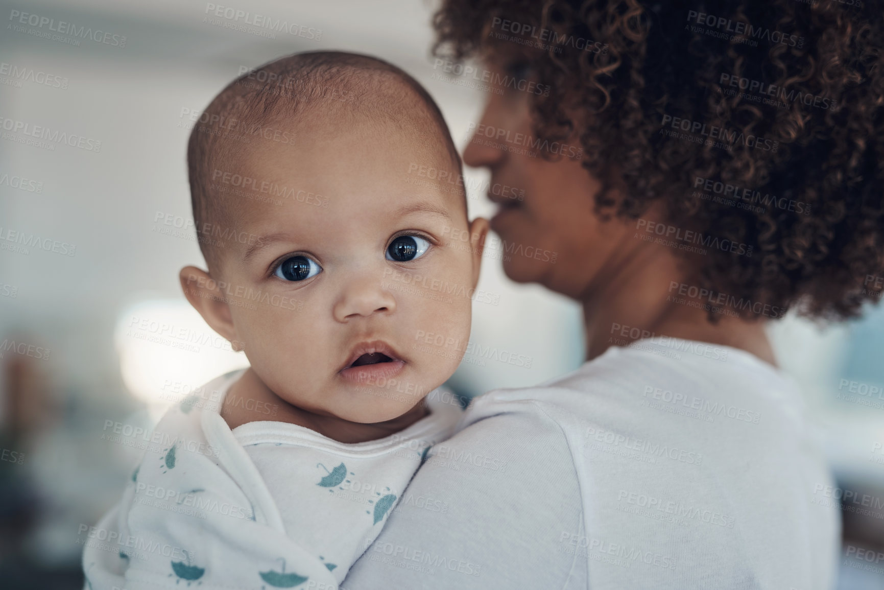 Buy stock photo Shot of a young woman carrying her adorable baby girl at home