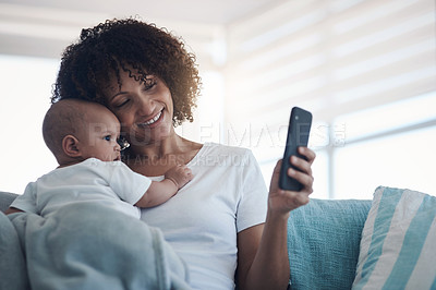 Buy stock photo Shot of a young woman taking selfies with her adorable baby girl at home