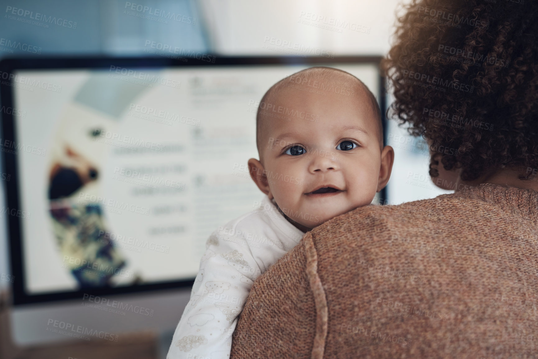 Buy stock photo Shot of a young woman using a computer while caring for her adorable baby girl at home