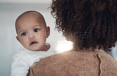 Buy stock photo Shot of a young woman carrying her adorable baby girl at home