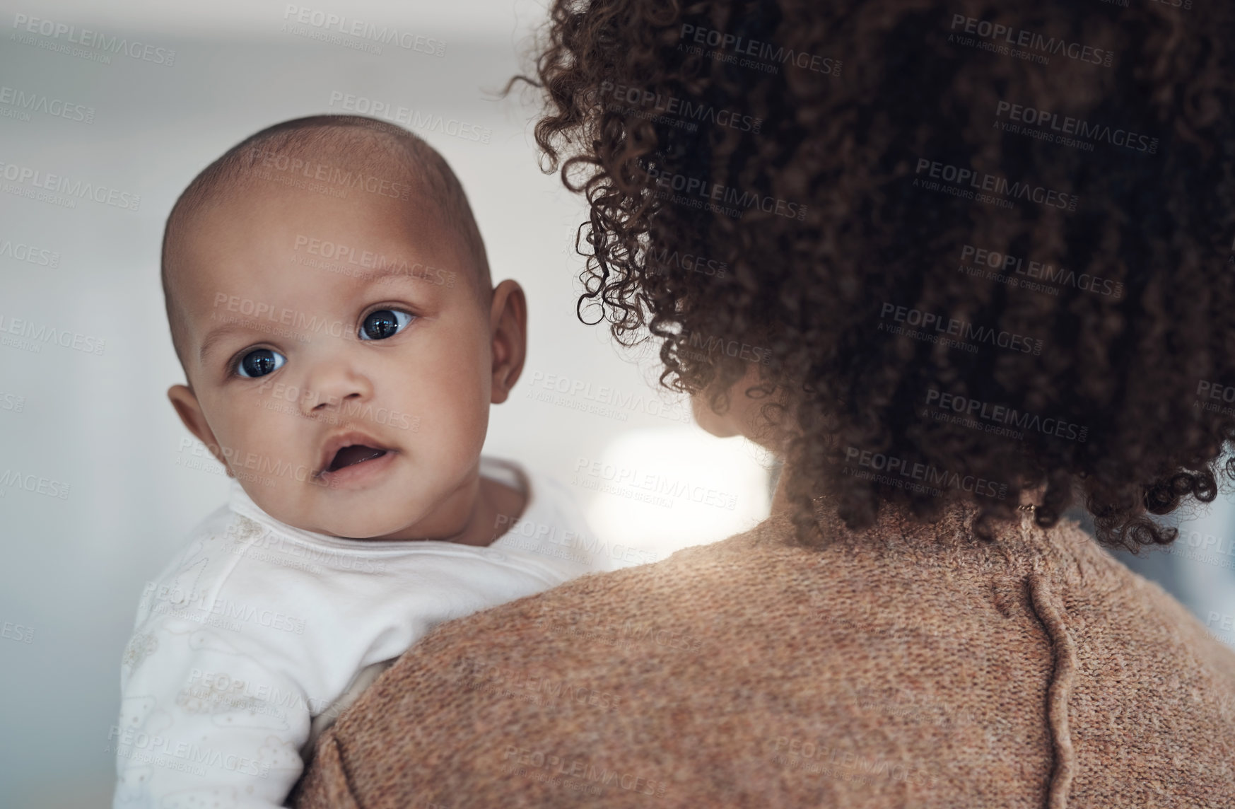 Buy stock photo Shot of a young woman carrying her adorable baby girl at home