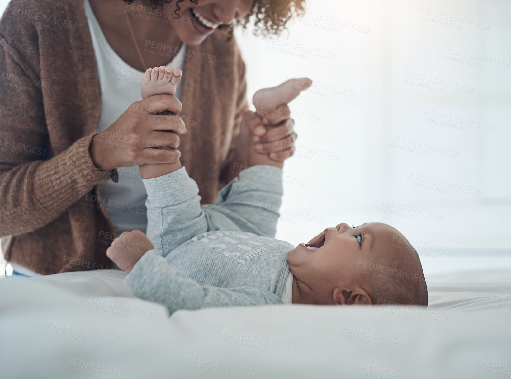 Buy stock photo Shot of a young woman playing with her adorable baby girl on the bed at home