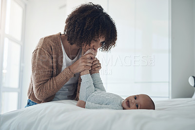 Buy stock photo Shot of a young woman playing with her adorable baby girl on the bed at home