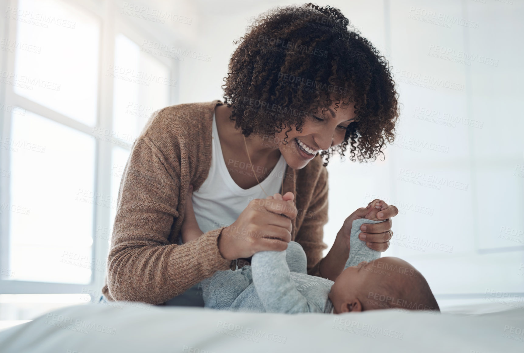 Buy stock photo Shot of a young woman playing with her adorable baby girl on the bed at home