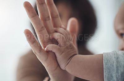 Buy stock photo Shot of an unrecognisable woman touching her baby’s hand at home