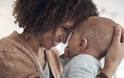 Buy stock photo Shot of a young woman carrying her adorable baby girl at home