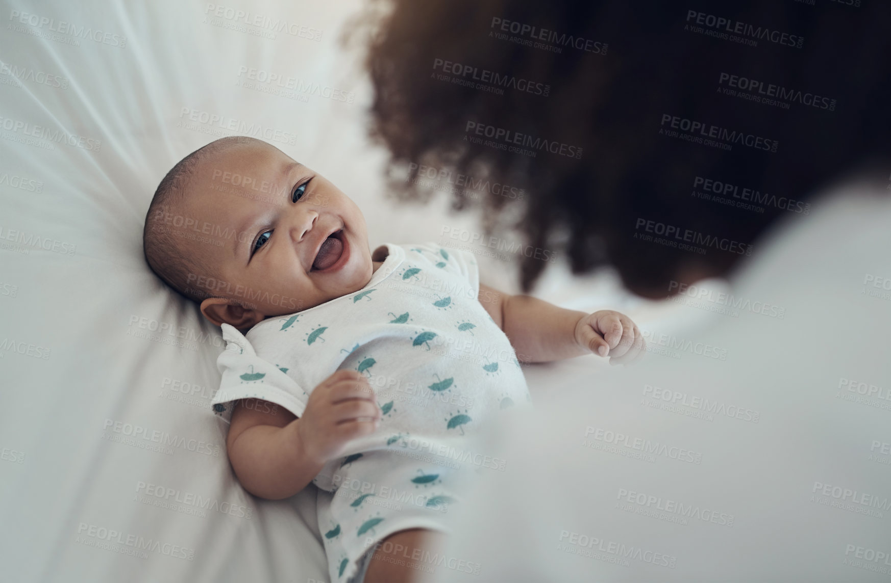 Buy stock photo Shot of an adorable baby girl gazing at her mother on the bed at home