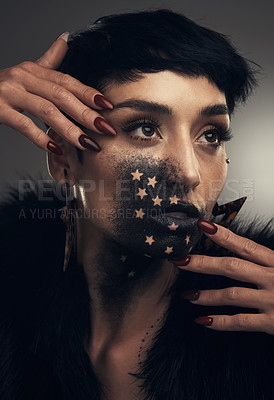 Buy stock photo Studio shot of a young woman posing with paint on her face on a grey background