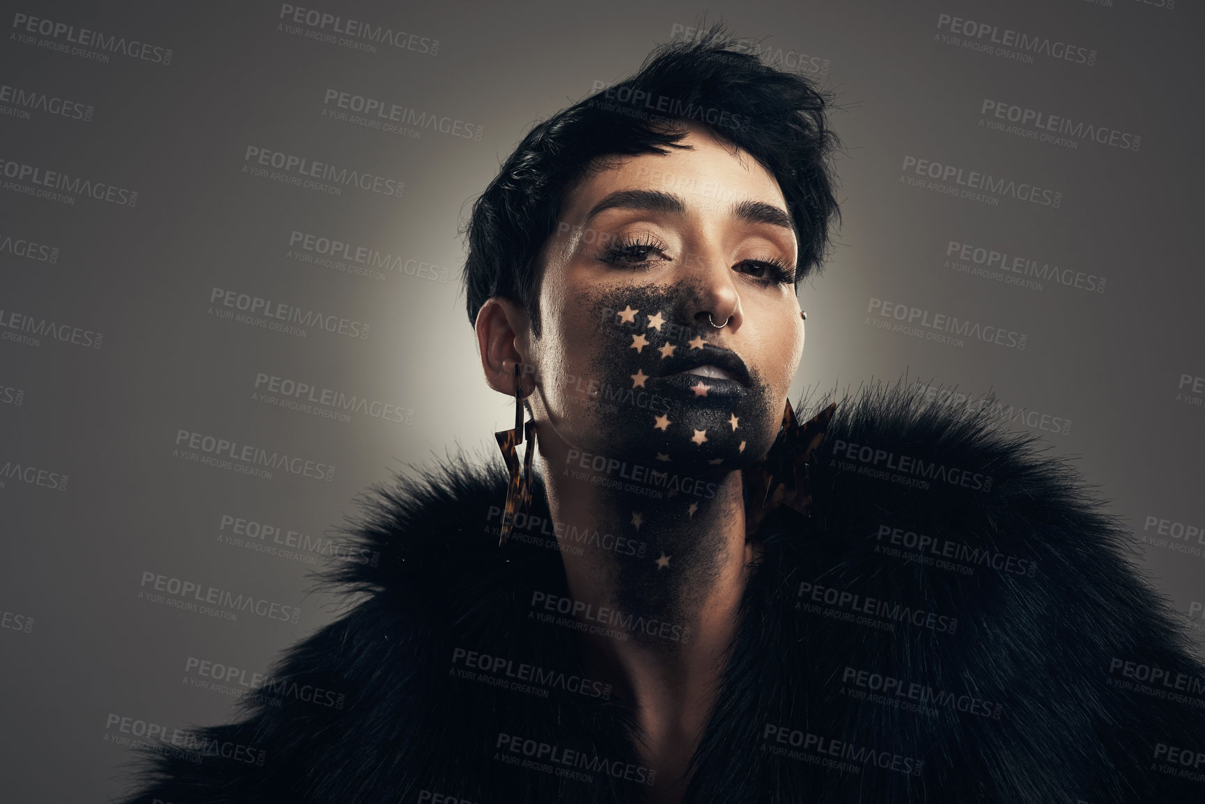 Buy stock photo Studio shot of a young woman posing with paint on her face on a grey background