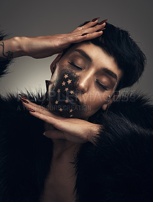 Buy stock photo Studio shot of a young woman posing with paint on her face on a grey background