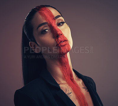 Buy stock photo Studio shot of a young woman posing with paint on her face on a grey background